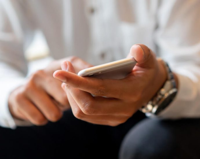 スマホの通知をオフにする男性